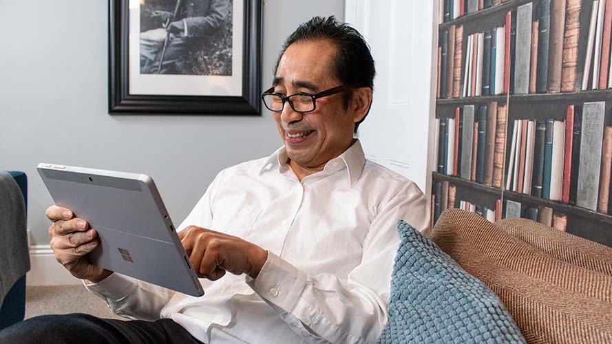 Man using a Windows tablet to read at home